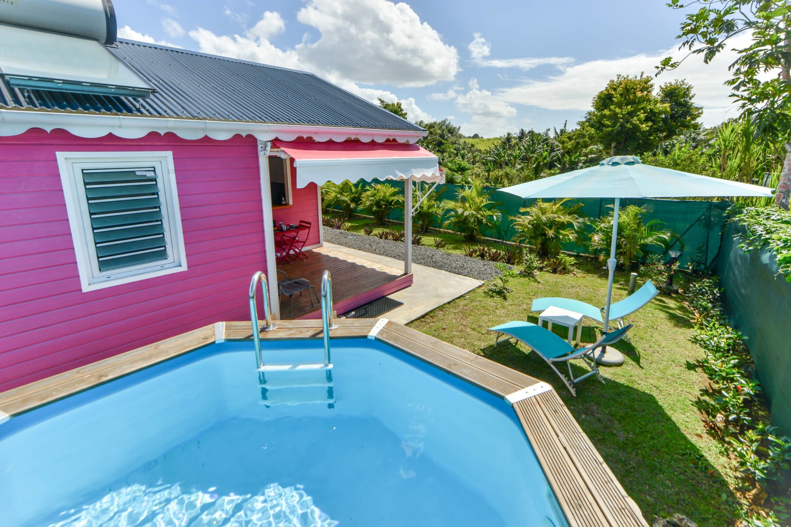 Bungalow rose, piscine et transats